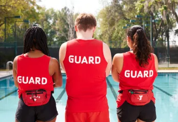 three lifeguards facing the pool