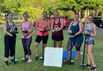 Six members of a Body Challenge group pose for a photo in a grassy area outside of the Betty J. Pullum YMCA.