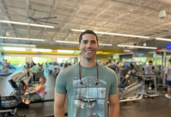 Community Y at Gulf Breeze member Brandon smiles for a photo on the wellness floor at the Bear Levin Studer Y, which he and his family are visiting while renovations are ongoing at Gulf Breeze.