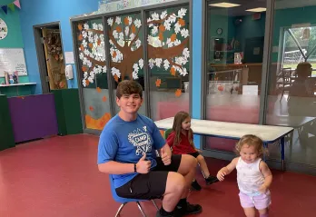 Jackson is pictured sitting with and supervising two children while they play in the KidZone at the Betty J. Pullum YMCA.