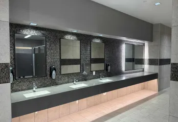 The newly renovated locker rooms and restrooms are pictured with a view of the sink and vanity areas.
