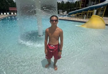 Lifeguard & Swim Instructor William is pictured standing in the shallow end of the pool at the Pullum Y.