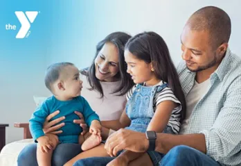 A photo of a smiling family with two children, presented with a Y logo in the corner.