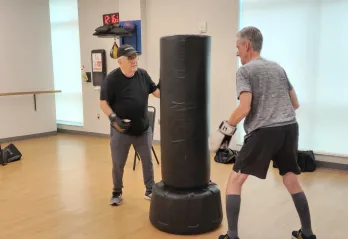Two participants in the Parkinson's Disease program at the Bear Levin Studer Y work through boxing exercises.