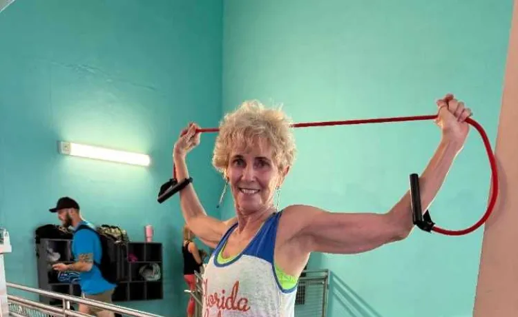 Linda smiles for a photo as she works out near the stairs on the wellness floor at the Bear Levin Studer Y.