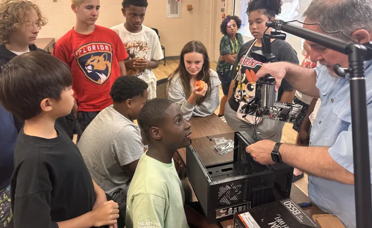 Tech Spark's Paul Brown leads a computer building workshop at teen camp, offering STEM education and a hands-on experience for the teens during the summer.
