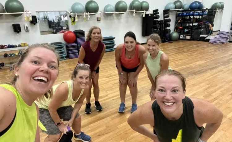 A group smiles and poses for a photo before starting group exercise at the Community YMCA at Gulf Breeze.