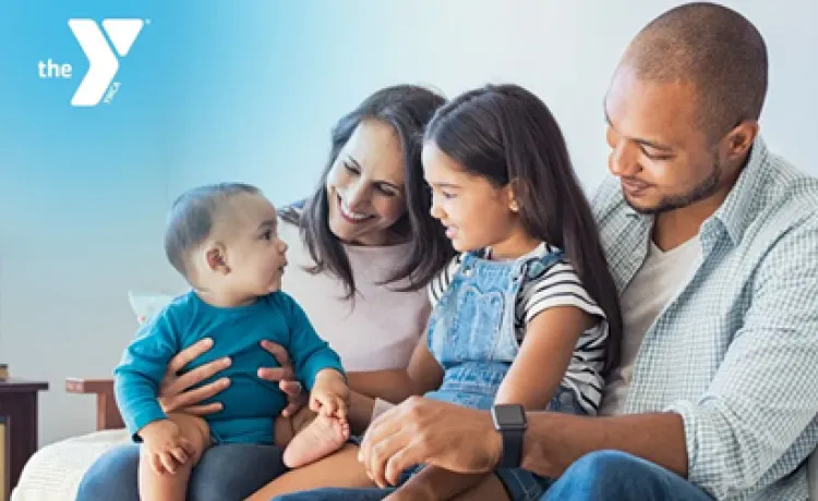 A photo of a smiling family with two children, presented with a Y logo in the corner.