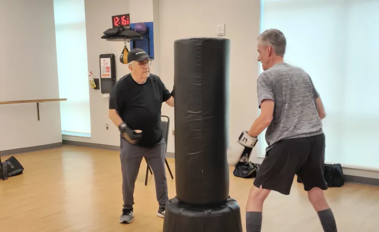 Two participants in the Parkinson's Disease program at the Bear Levin Studer Y work through boxing exercises.