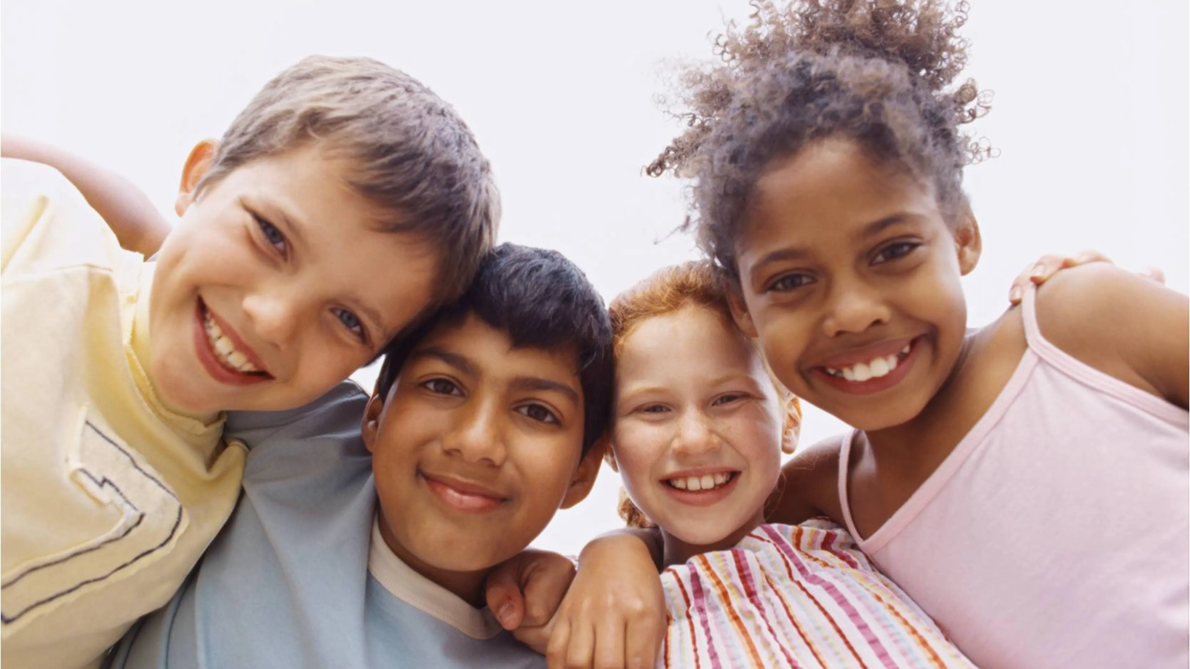 4 kids arm in arm in a huddle