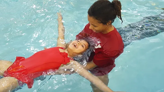 instructor teaching child to swim