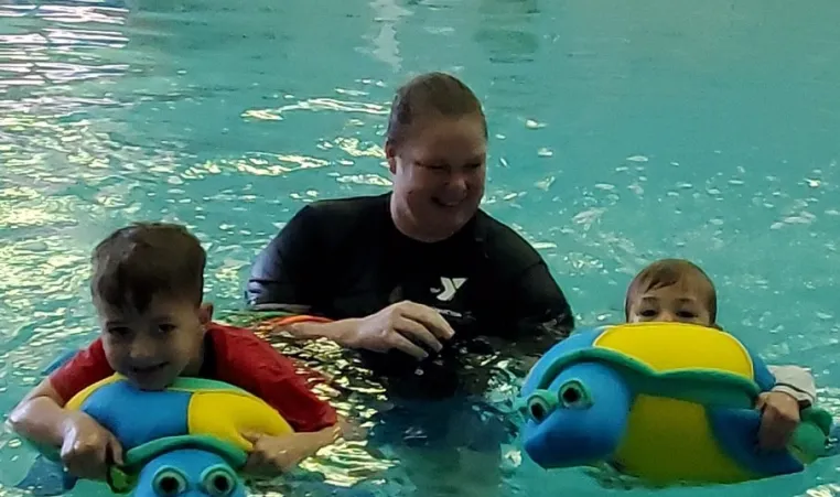 instructor teaches swim lesson