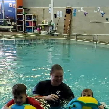 instructor teaches swim lesson