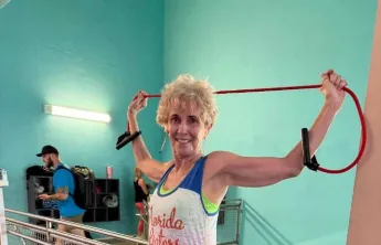 Linda smiles for a photo as she works out near the stairs on the wellness floor at the Bear Levin Studer Y.