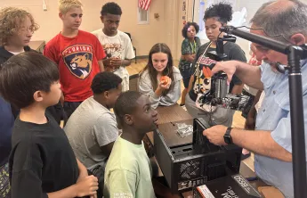 Tech Spark's Paul Brown leads a computer building workshop at teen camp, offering STEM education and a hands-on experience for the teens during the summer.